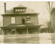 FloodGallery10 Two homeowners stand on their roof on Fourth St.