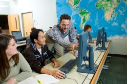 A faculty member works with students in the classroom.