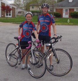 Photo of two Wright State students dressed in bicycling uniforms standing next to their bicycles.