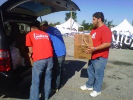 Photo of three volunteers unloading a van of church donations.