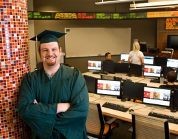 Photo of Jon Ritchey wearing his graduation cap and gown.