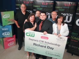 Photo of Richard Day, center holding check, receiving scholarship check with family surrounding him.
