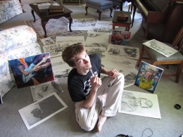 Photo of Anthony Powers, a synesthete and an artist sitting on the floor in a living room working on his art.