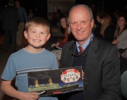 Photo of Ballard with a young boy holding a Titanic book.