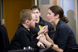 Photo of Zach Holler talking with a personal assistant.