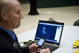 Photo of Greg Scharer, executive director of the office of alumni relations monitoring the streaming internet feed and the Twitter account that alumni used to submit questions.