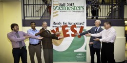 Photo of Her Dregalla, Thomas Sudkamp, Dan Krane and student government representatives posing in front of a semster conversion banner.