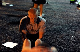 Photo of Brian Bolibrzuch helping a fellow cadet perform situps during the Leader’s Training Course.