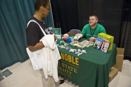 A photo of an employee visiting at a table during the the 2011 Health and Benefits fair.