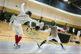 Photo of two people competing in a fencining tournament at the Wright State University Nutter Center.