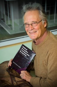 Photo of political science professor Charles Funderburk with the book Political Corruption in Comparative Perspective, which he and six other faculty members partnered to produce.