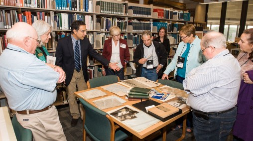 Archivist Gino Pasi pointing out an item in the aviation history materials in Wright State's Special Collections and Archives during a tour of the archives by prominent aviation writers.
