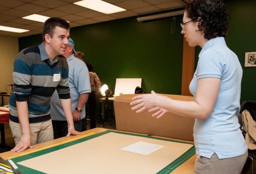 Lisa Rickey, archivist for digital initiatives and outreach, right, talking to Serbian librarian Mirko Masic about building an archival box. Librarians from Serbia visited to Wright State's Dunbar Library to learn about Maker Spaces in libraries. (Photo by Erin Pence)