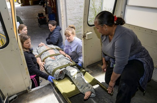Participants practiced loading a mannequin into converted school bus designed to carry patients.