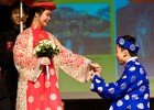Photo of a young man "proposing" to a young woman, both dressed in Asian clothing.