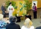 Photo of the tea mistress, wearing a kimono, in front of an audience.