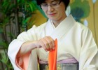 Photo of the tea mistress folding an orange cloth napkin.
