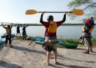 Photo of students and instructors raising kayak ores over there heads.