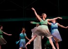 Photo of a dancer in green leaping into the air.