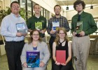 Photo of six students, each holding a book.