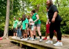 Photo of several little sibs line dancing on a small wooden bridge in the Wright State woods.