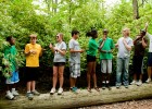 Photo of several little sibs of Wright State students posing together on a log during an activity during Little Sibs Weekend.