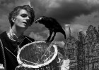 Photo of a boy dressed in medival clothes with a raven and a basket.