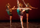 Photo of three dancers, each on one foot.