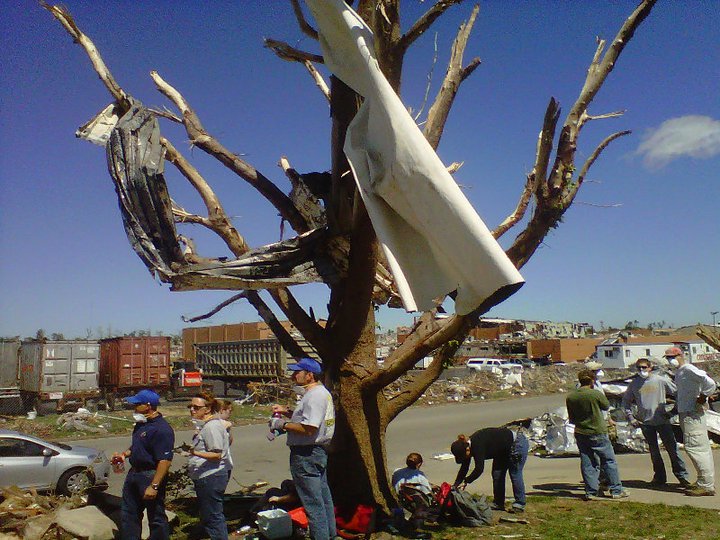 Photo of volunteers beside a large tree destroyed by the EF5 tornado.