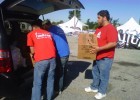 Photo of three volunteers unloading a van of church donations.