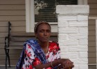 Photo of African refugee sitting on a front stoop of a home in Dayton during a block party.