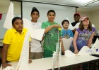 Photo of six pre-teen students showing off their roller coasters they made in the "Investigation STEM" pre college camp.