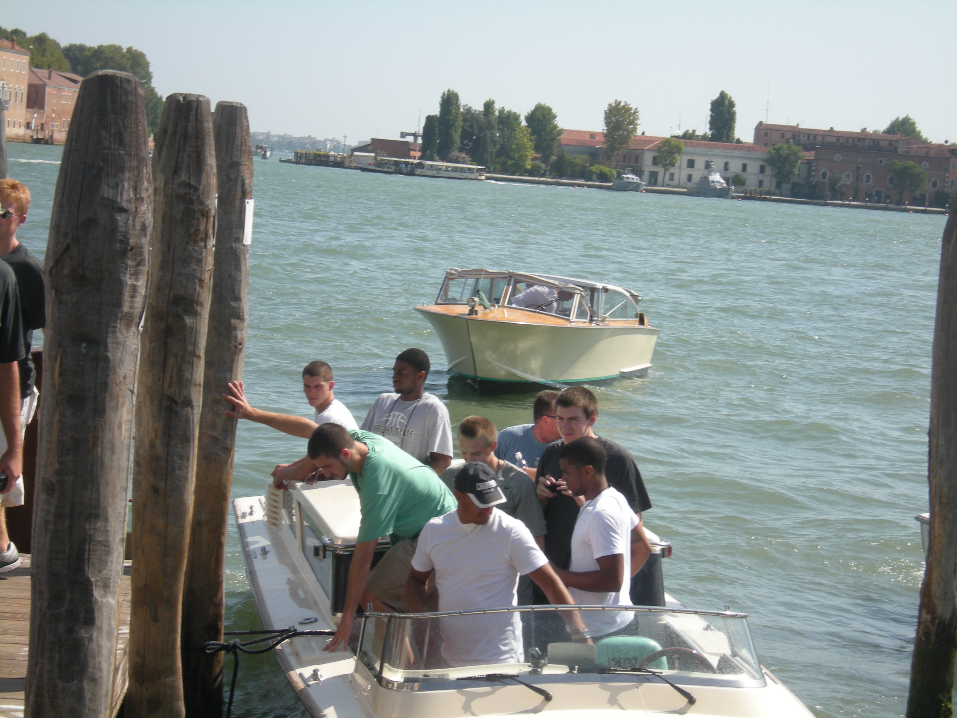 Photo of various members of the Wright State men's basketball team boarding gondullas in Venice, Italy.