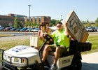 Photo of a volunteer taking a student to her building on a golf cart.