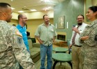 Photo of five people talking. Two are in military uniform.