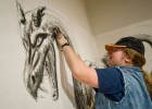 A student sketches a large dragon on the walls at the Stein Galleries