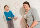 Photo of a mom and a daughter with their drawing.