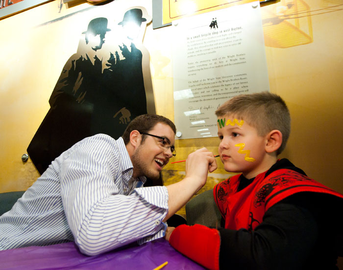 Photo of a student painting a child's face