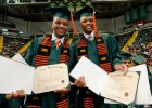 Photo of two African-American students showing off their diplomas.