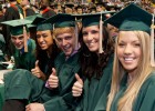 Photo of several students in green graduation attire giving the "thumbs up" guesture.