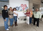 Photo of board members and volunteers from FLOC (For Love of Children) pose outside the Toy Cottage located in downtown Dayton which serves Montgomery County Children Services.