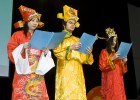 Photo of three students dressed in Asian garb on stage giving the report of the year for the World, the U.S. and Wright State.