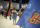 Photo of students parading through the Apoillo Room at the Srtudent Union with flags from their home country.