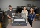 Photo of Biomedical engineering students Jessica Hernandez (right), Joanna Newton and Jacob Durdel displayimg the incubator they designed and built. The incubator and others will be sent to the Congo in Africa.