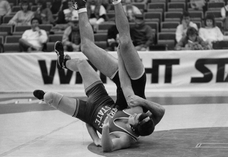 Photo of McClintock as a Wright State wrestler grappling on the mat.