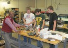 Photo of Ruby Mawasha, Jordon Coffman, John Neifert and Jared Runyon working on their battle bot Crimson Chaos.