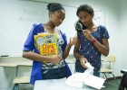 Photo of Kaelyn Sanders and Ayanna Madison investigating some tiny evidence in Forensic Analysis Camp.