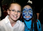 Photo of two kids, one with face painted blue as a creature from Avatar.
