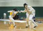 Photo of two people competing in a fencining tournament at Wright State University's Nutter Center.