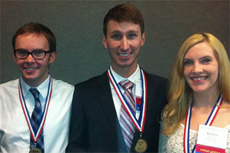 Photo of three students with medals